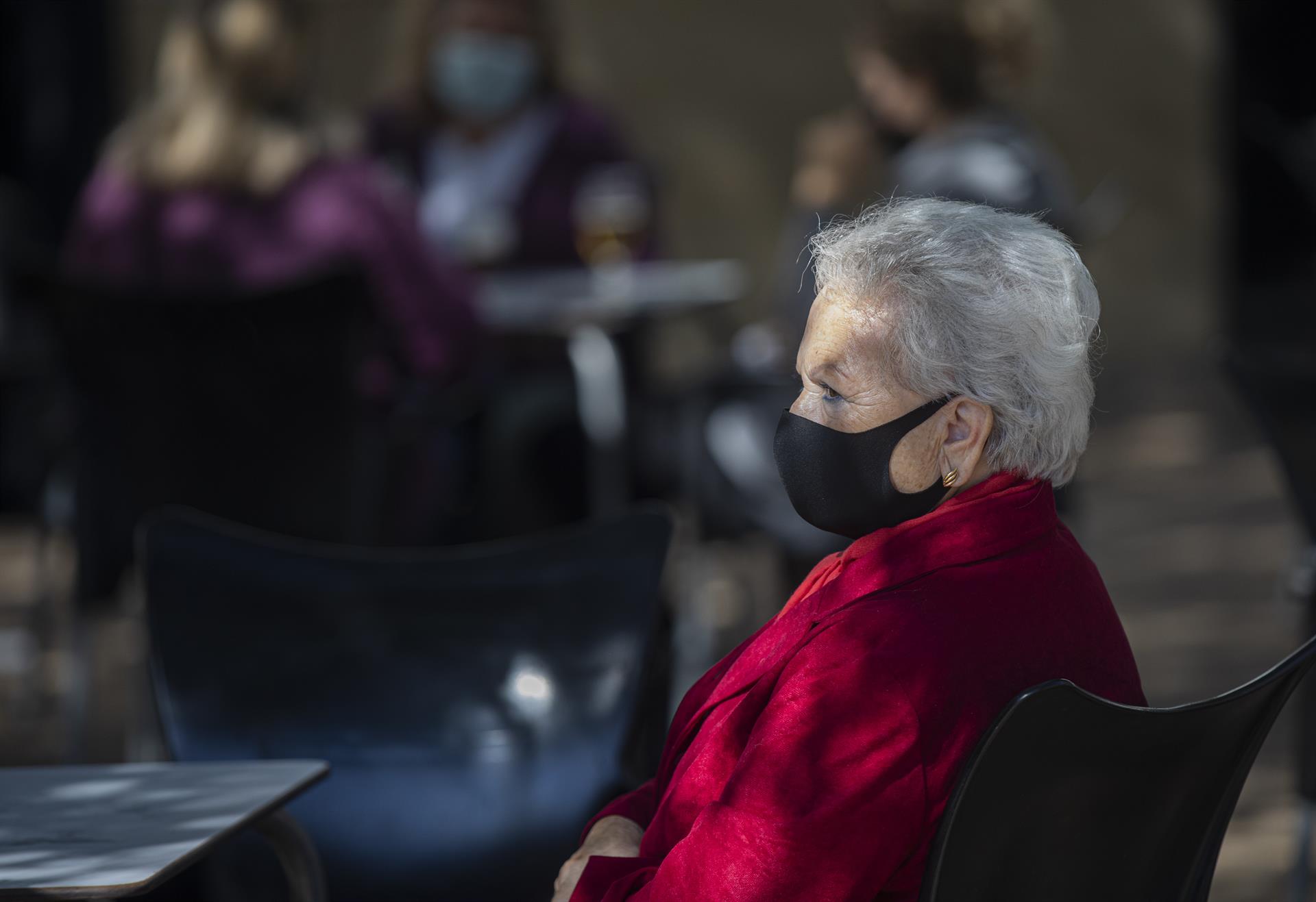 Una mujer mayor con mascarilla en la terraza de un bar. / Foto: María José López. / Europa Press.