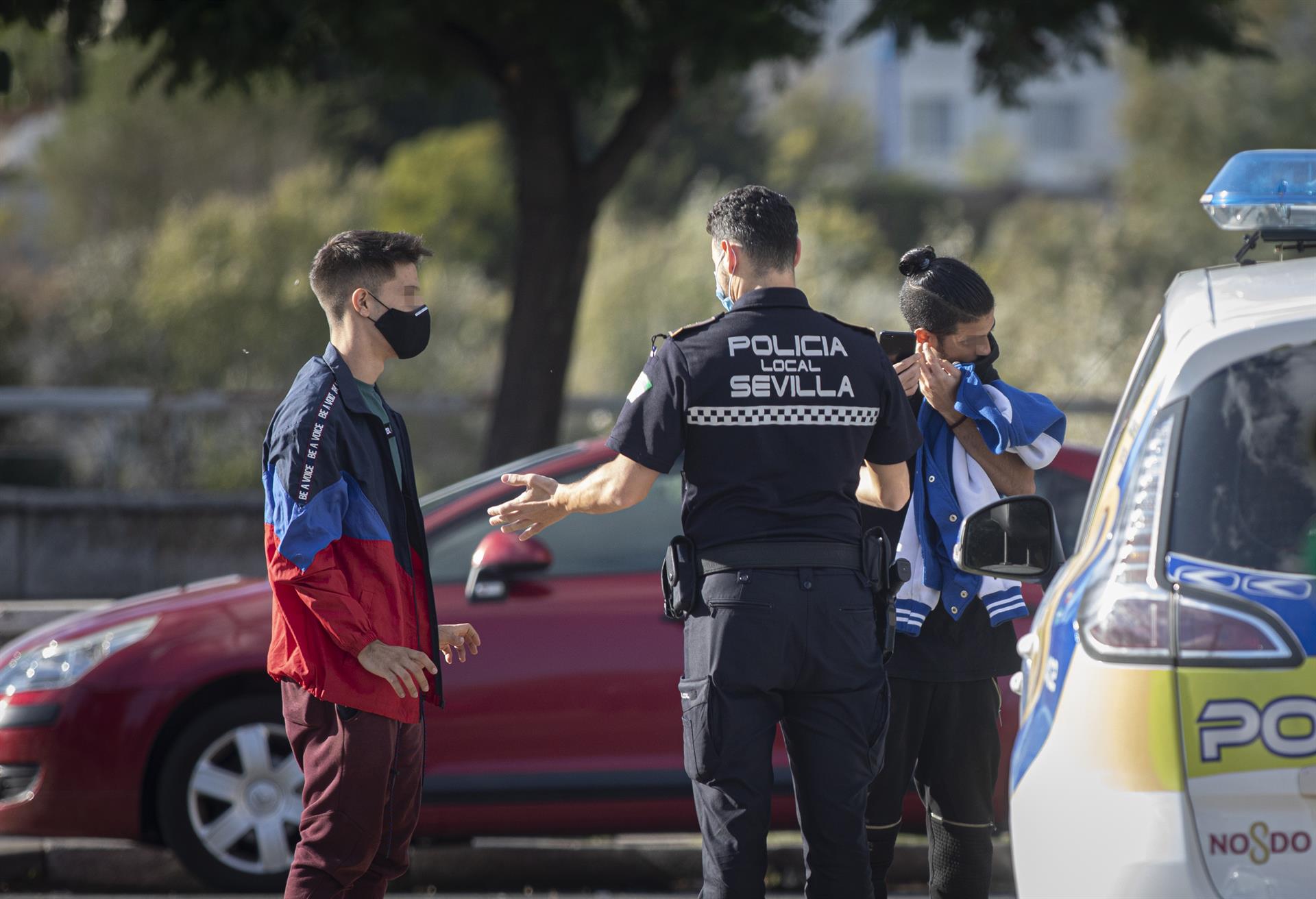 Un agente de la policía local para a un joven por no llevar mascarilla. / Foto: María José López. / Europa Press.