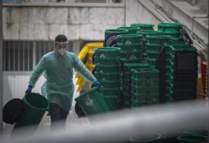 Un trabajador sanitario apila cubetas de residuos en el Hospital Virgen Macarena. / Foto: Archivo / María José López. / Europa Press.