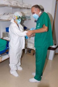 Un doctor del Hospital Reina Sofía ayuda a la colocación de un EPI. / Foto: Junta de Andalucía. / Europa Press.