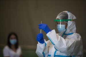 Una sanitaria atiende a una mujer durante las pruebas de cribado de covid-19 con test de antígenos en pabellones deportivos de la ciudad. / Foto: María José López. / Europa Press.