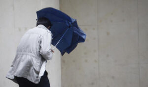 Un hombre se protege con un paraguas de la lluvia y el viento. / Foto: Agencia EFE. / Junta de Andalucía.