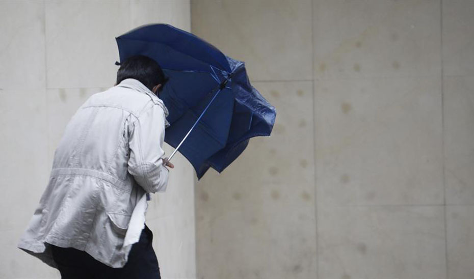 Un hombre se protege con un paraguas de la lluvia y el viento. / Foto: Agencia EFE. / Junta de Andalucía.