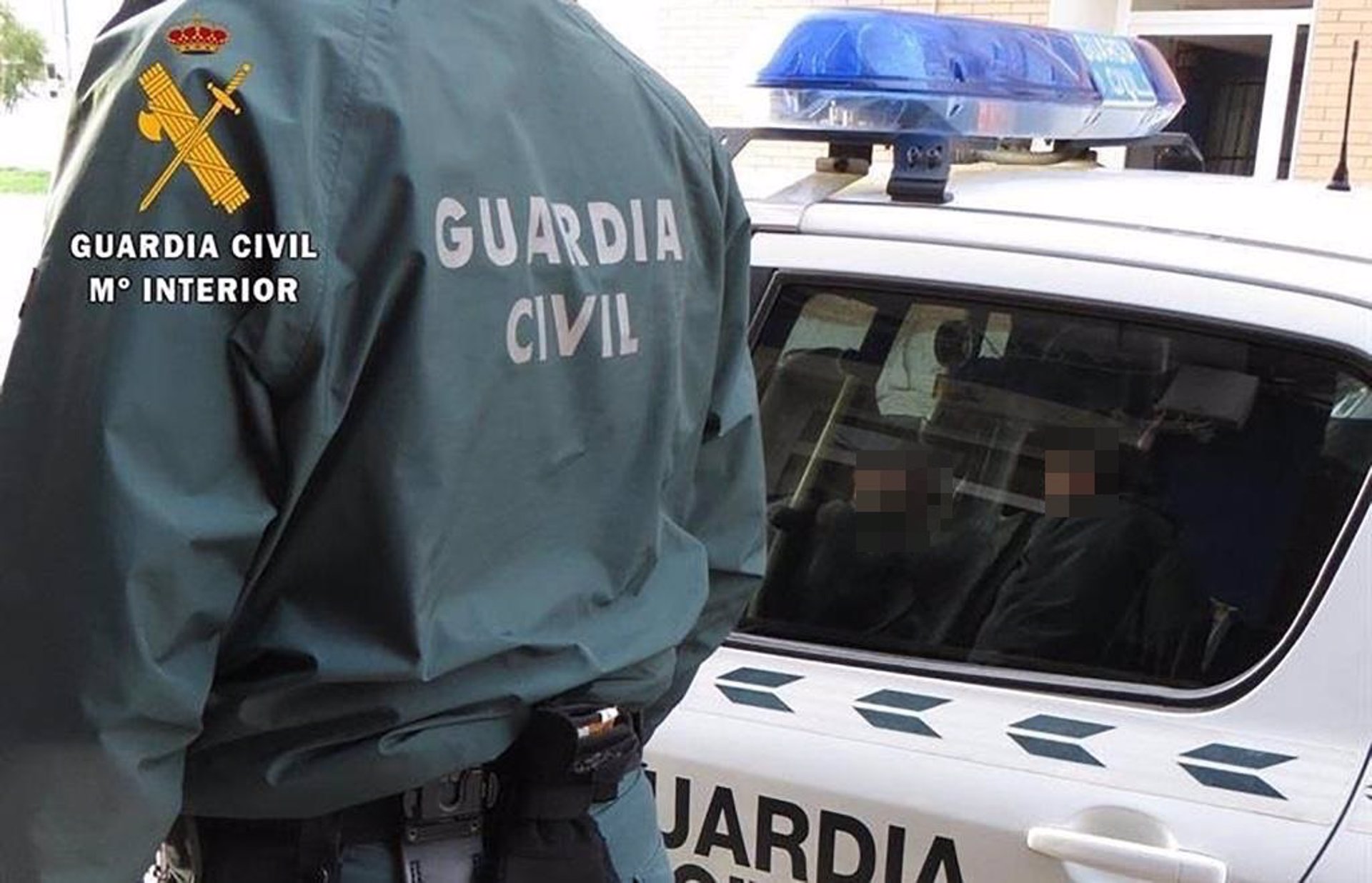 Un agente de la Guardia Civil junto a un coche patrulla. / Foto: Guardia Civil. / Europa Press.